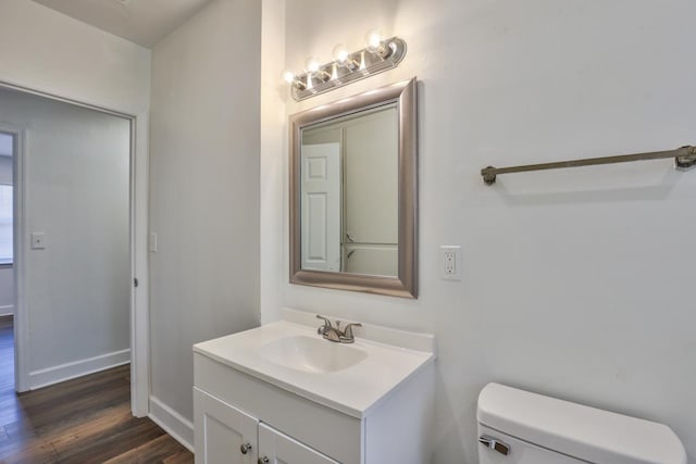 bathroom featuring wood-type flooring, vanity, and toilet