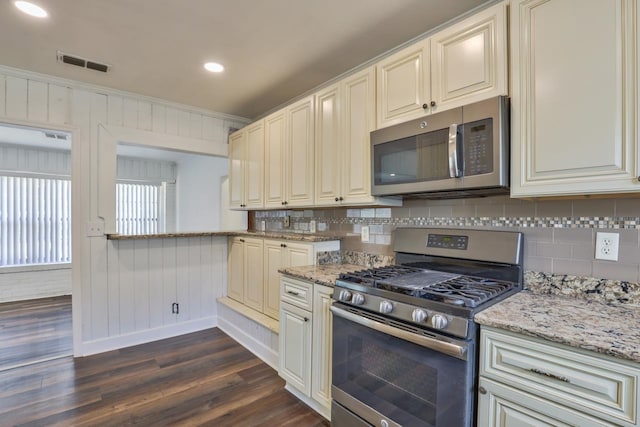 kitchen featuring stainless steel appliances, light stone counters, tasteful backsplash, dark hardwood / wood-style floors, and crown molding