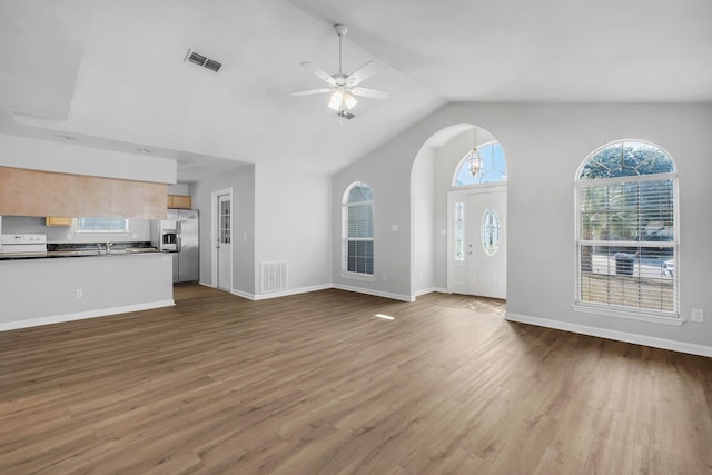 unfurnished living room with ceiling fan, vaulted ceiling, and hardwood / wood-style floors