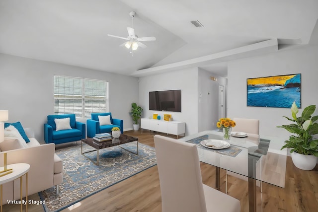 living room featuring ceiling fan, vaulted ceiling, and wood-type flooring