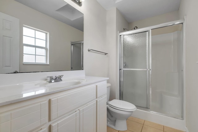 bathroom with tile patterned flooring, vanity, toilet, and a shower with shower door