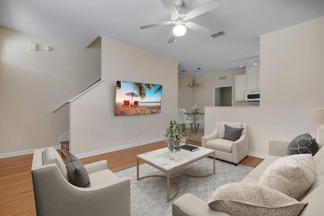 living room with light wood-type flooring, ceiling fan, and rail lighting