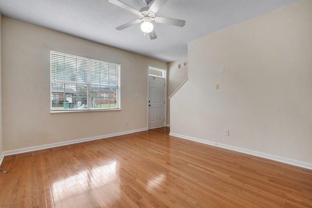 spare room featuring light hardwood / wood-style flooring, ceiling fan, and a textured ceiling