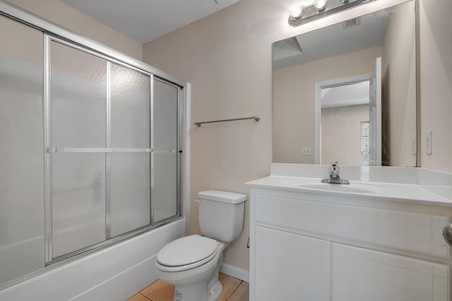 full bathroom with tile patterned flooring, toilet, vanity, and shower / bath combination with glass door