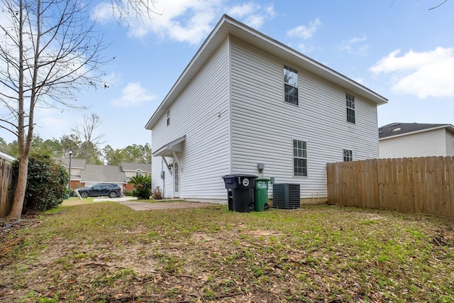 view of side of property with central AC unit and a yard