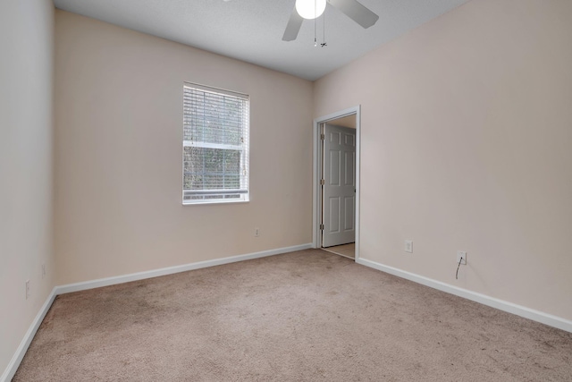 spare room featuring ceiling fan and light carpet