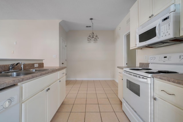 kitchen with sink, white appliances, white cabinetry, and decorative light fixtures