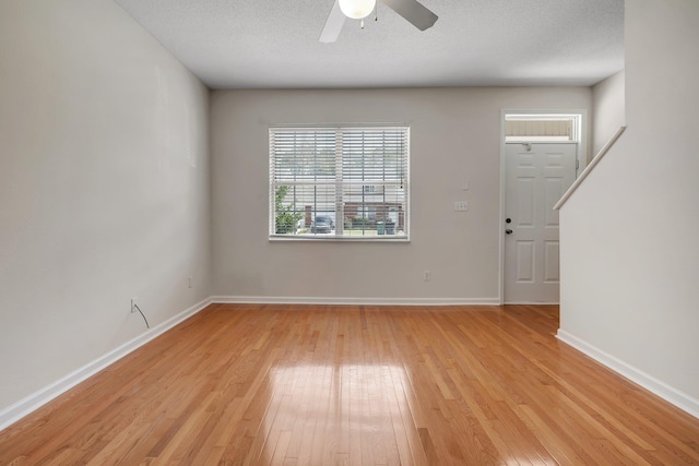 interior space featuring light hardwood / wood-style floors, ceiling fan, and a textured ceiling