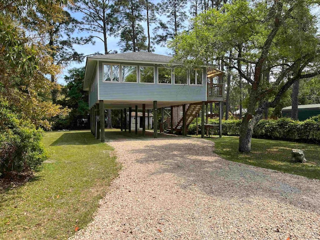 view of front of property featuring a front yard, a sunroom, and a carport