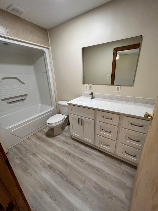 full bathroom with toilet, vanity, hardwood / wood-style floors, and bathing tub / shower combination