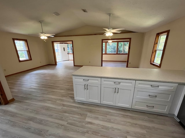 kitchen with white cabinetry, light hardwood / wood-style flooring, and vaulted ceiling