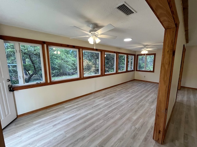 interior space featuring a textured ceiling, light hardwood / wood-style flooring, and ceiling fan