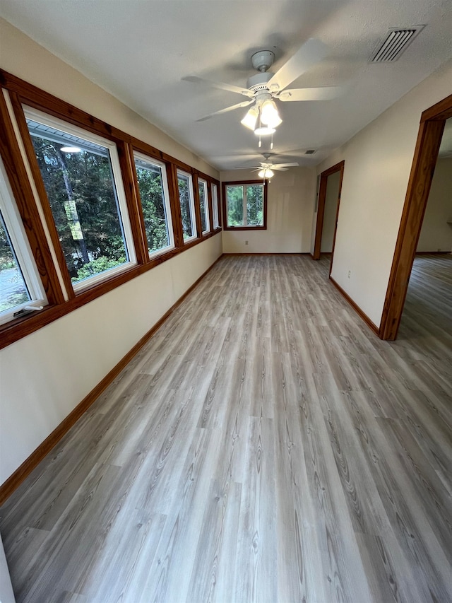 empty room with light wood-type flooring and ceiling fan