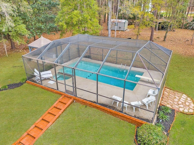 view of swimming pool with a patio, a lanai, and a yard