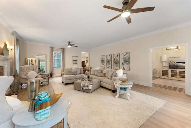 living room with crown molding, ceiling fan, and light hardwood / wood-style floors