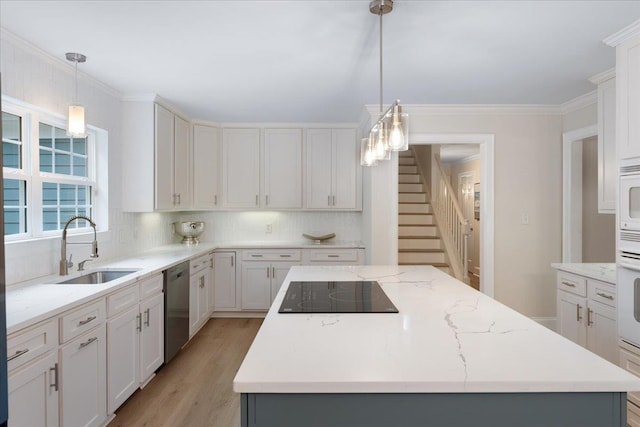 kitchen featuring sink, white appliances, decorative light fixtures, and a center island