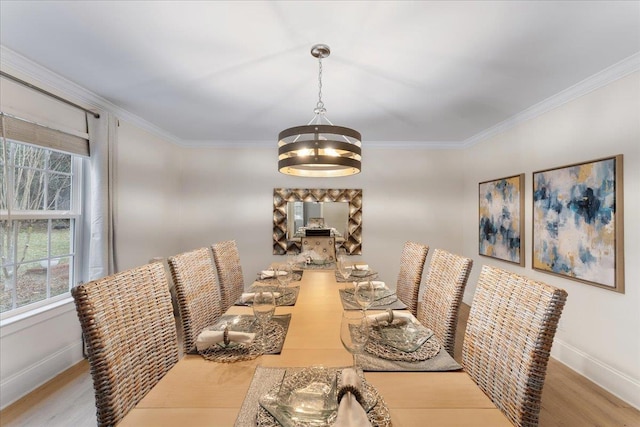 dining space featuring ornamental molding, a chandelier, and light wood-type flooring