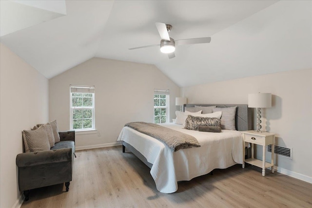 bedroom featuring multiple windows, lofted ceiling, ceiling fan, and light hardwood / wood-style flooring