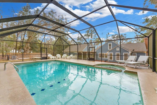 view of pool with an in ground hot tub, glass enclosure, and a patio