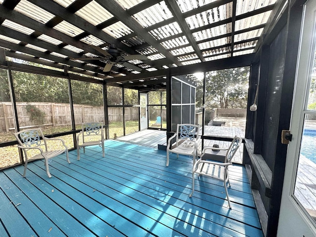 wooden terrace featuring glass enclosure and fence