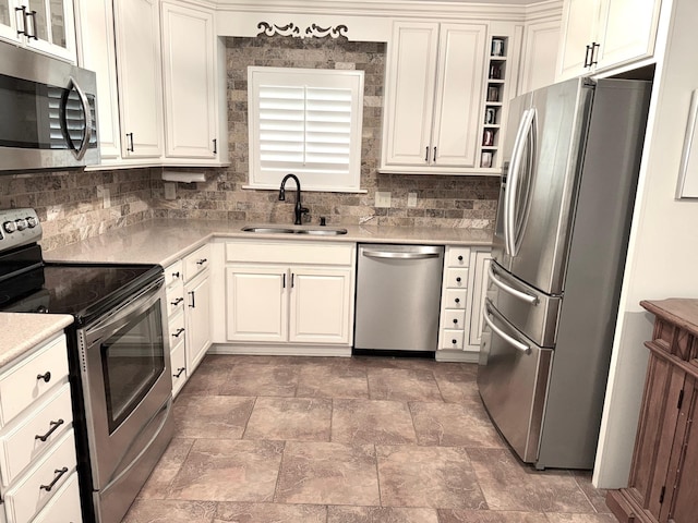 kitchen featuring backsplash, appliances with stainless steel finishes, light countertops, and a sink