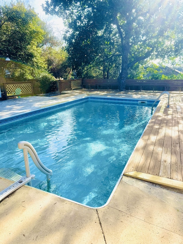 view of swimming pool with a fenced backyard, a deck, and a fenced in pool