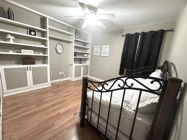 bedroom with wood finished floors, a ceiling fan, and baseboards