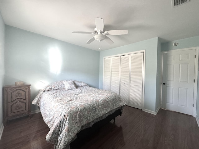 bedroom with ceiling fan, wood finished floors, visible vents, baseboards, and a closet