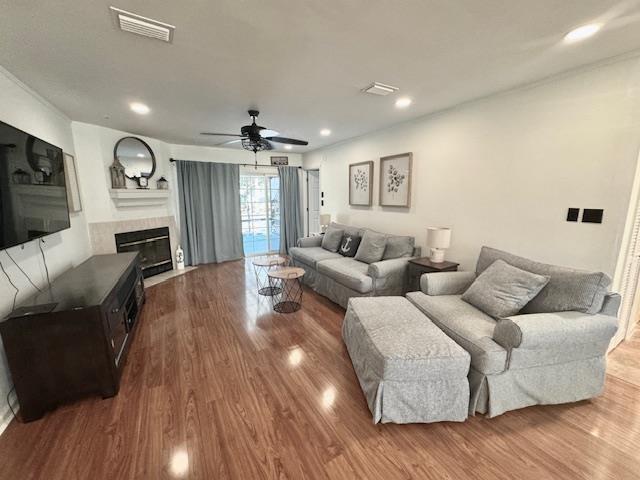 living room with recessed lighting, a fireplace, wood finished floors, a ceiling fan, and visible vents