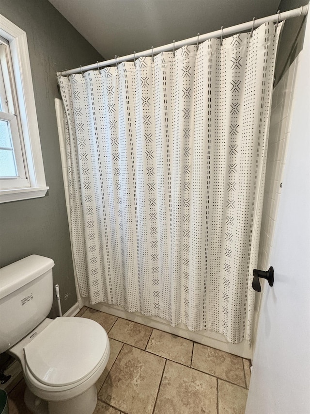 bathroom featuring curtained shower and toilet