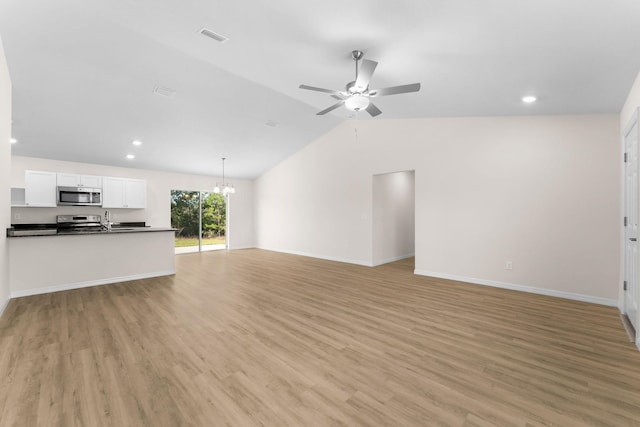 unfurnished living room featuring ceiling fan with notable chandelier, light hardwood / wood-style flooring, lofted ceiling, and sink