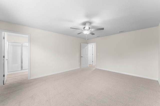 empty room featuring ceiling fan and light colored carpet