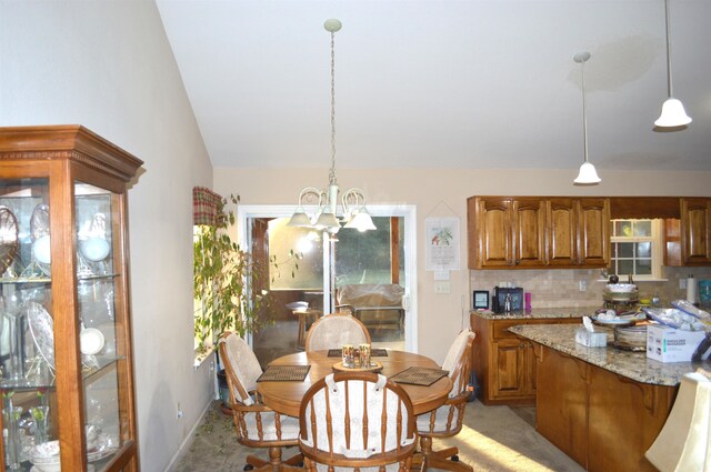 carpeted dining area with a wealth of natural light, lofted ceiling, and a notable chandelier