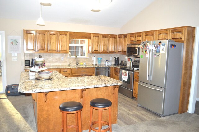 kitchen featuring hardwood / wood-style flooring, sink, appliances with stainless steel finishes, tasteful backsplash, and lofted ceiling