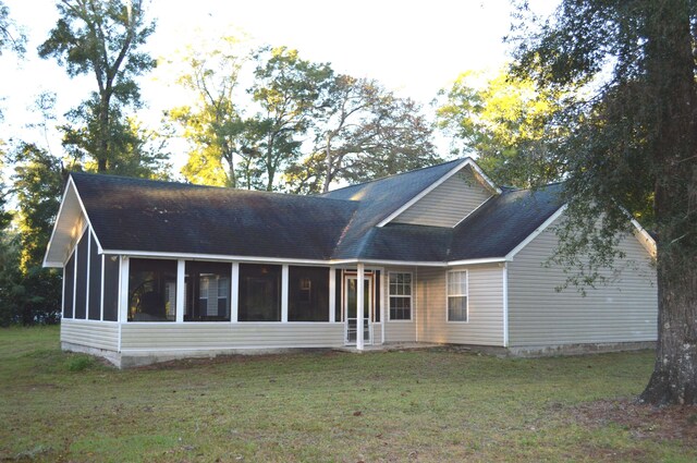 back of house with a sunroom and a yard