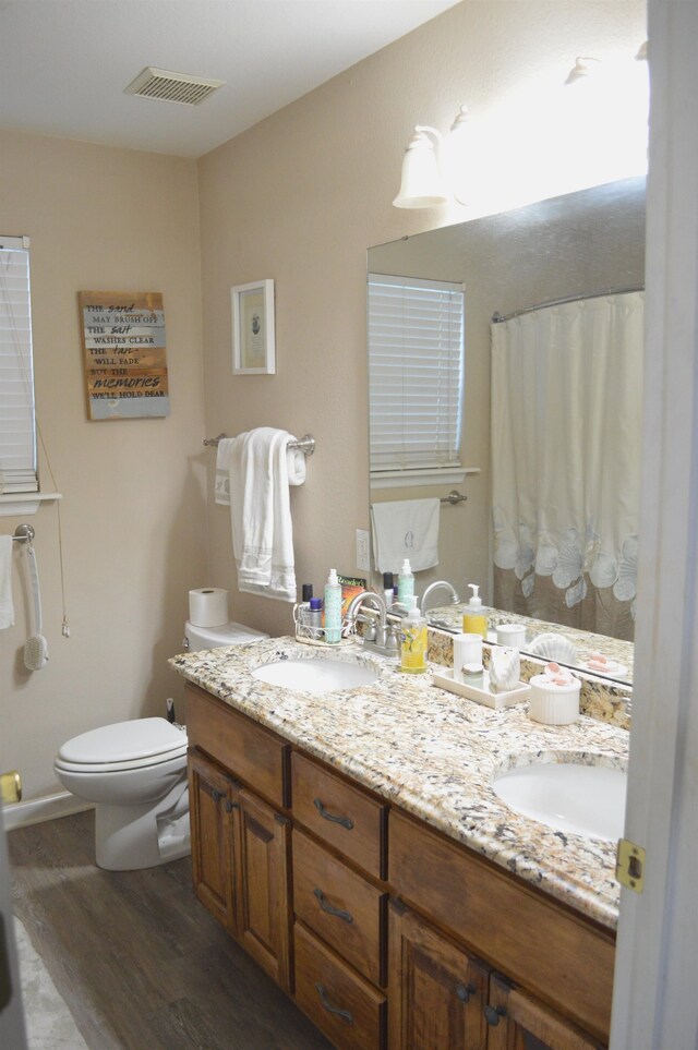 bathroom featuring hardwood / wood-style floors, curtained shower, vanity, and toilet