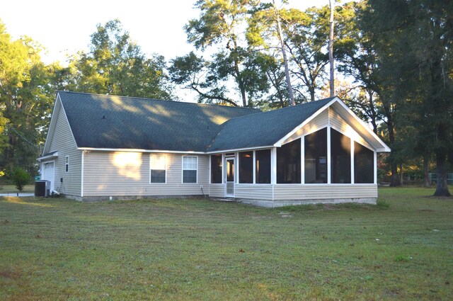 back of property featuring a lawn, central AC, and a sunroom