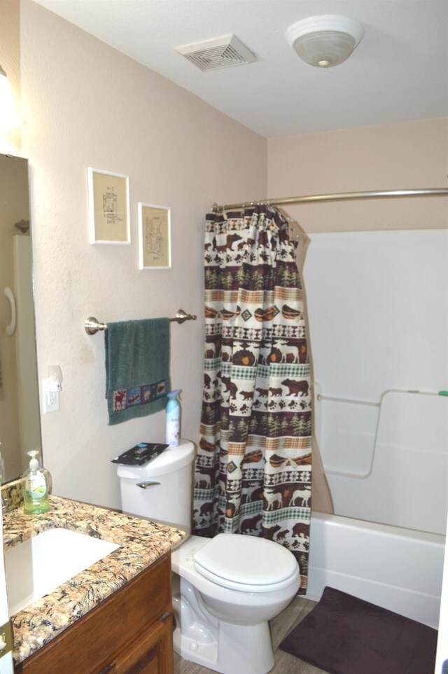 full bathroom featuring shower / tub combo with curtain, vanity, and toilet