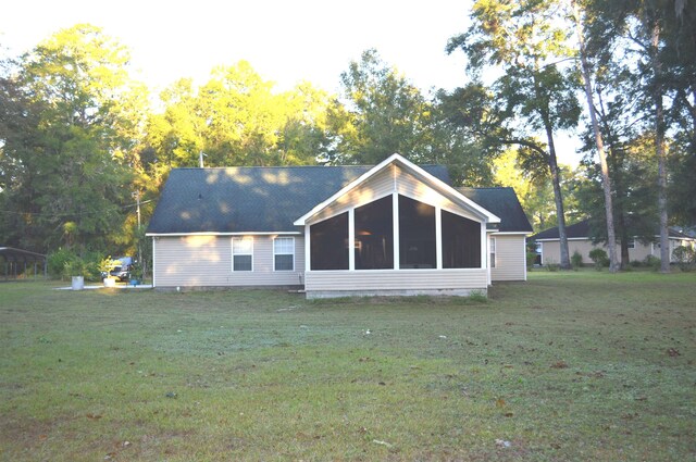 rear view of property with a lawn and a sunroom