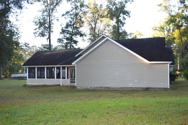 view of side of home featuring a sunroom and a yard