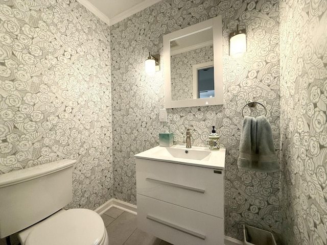 half bath with tile patterned flooring, wallpapered walls, toilet, ornamental molding, and vanity