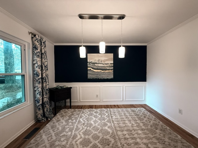 interior space with visible vents, wood finished floors, and ornamental molding