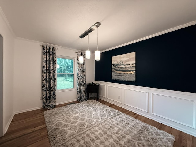 unfurnished dining area featuring visible vents, wainscoting, crown molding, and wood finished floors