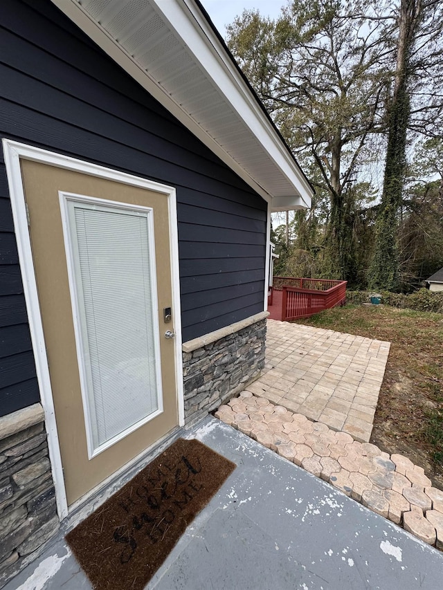 2408 Ionic Ct, Tallahassee, FL 32303 - view of exterior entry featuring stone siding, a wooden deck, and a patio area