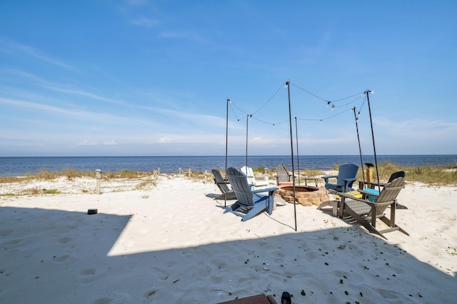 exterior space with a beach view and a fire pit