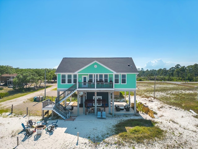 back of house featuring a fire pit, a patio area, and exterior bar