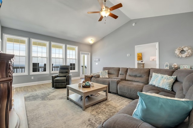 living room with ceiling fan, lofted ceiling, and light hardwood / wood-style flooring