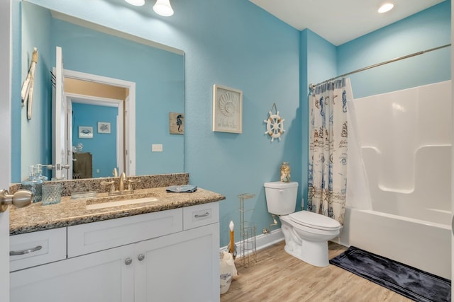 full bathroom featuring toilet, vanity, hardwood / wood-style flooring, and shower / tub combo with curtain