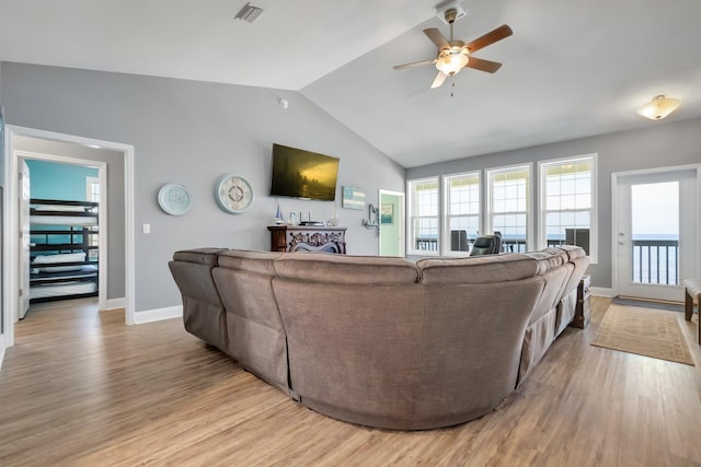 living room featuring ceiling fan, light hardwood / wood-style floors, and lofted ceiling