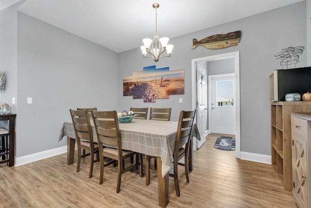 dining area featuring light hardwood / wood-style flooring and a notable chandelier